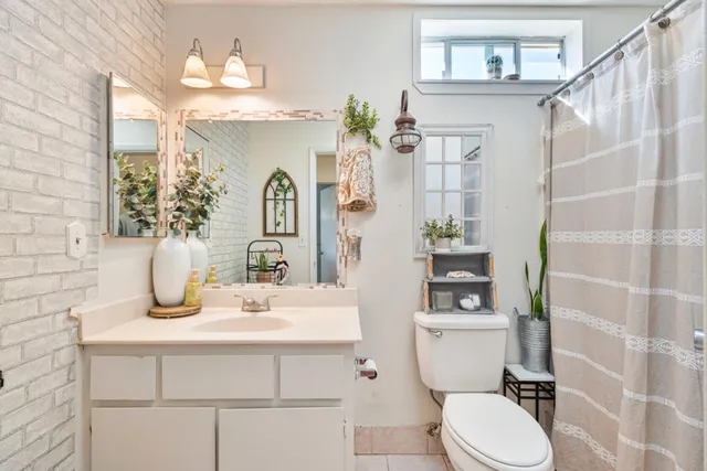 a bathroom with a sink a toilet and shower curtain