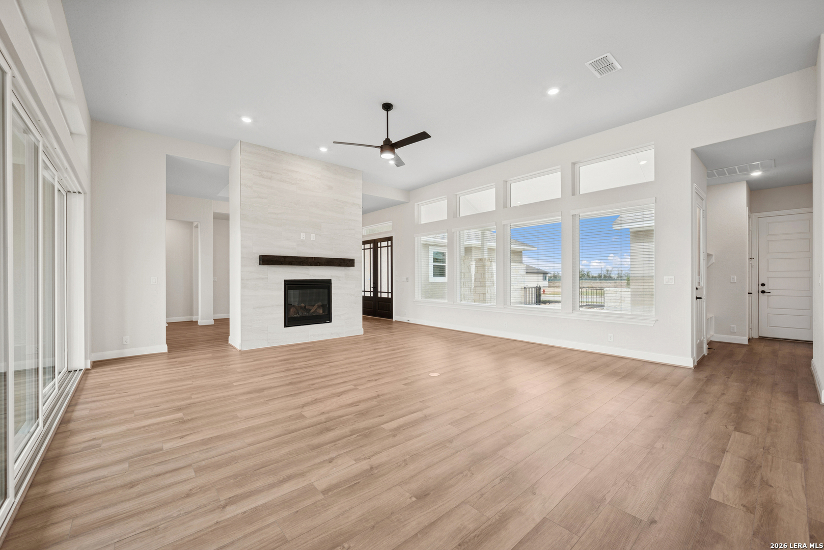 761 Falcon Cove Castroville, TX 78009 - Photo 11 of 11 an empty room with wooden floor fireplace and windows