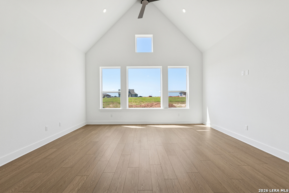761 Falcon Cove Castroville, TX 78009 - Photo 6 of 11 a view of an empty room with a window and wooden floor