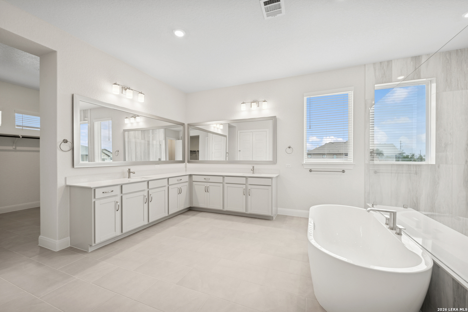 761 Falcon Cove Castroville, TX 78009 - Photo 8 of 11 a large white bathroom with a double vanity sink a mirror and a bathtub
