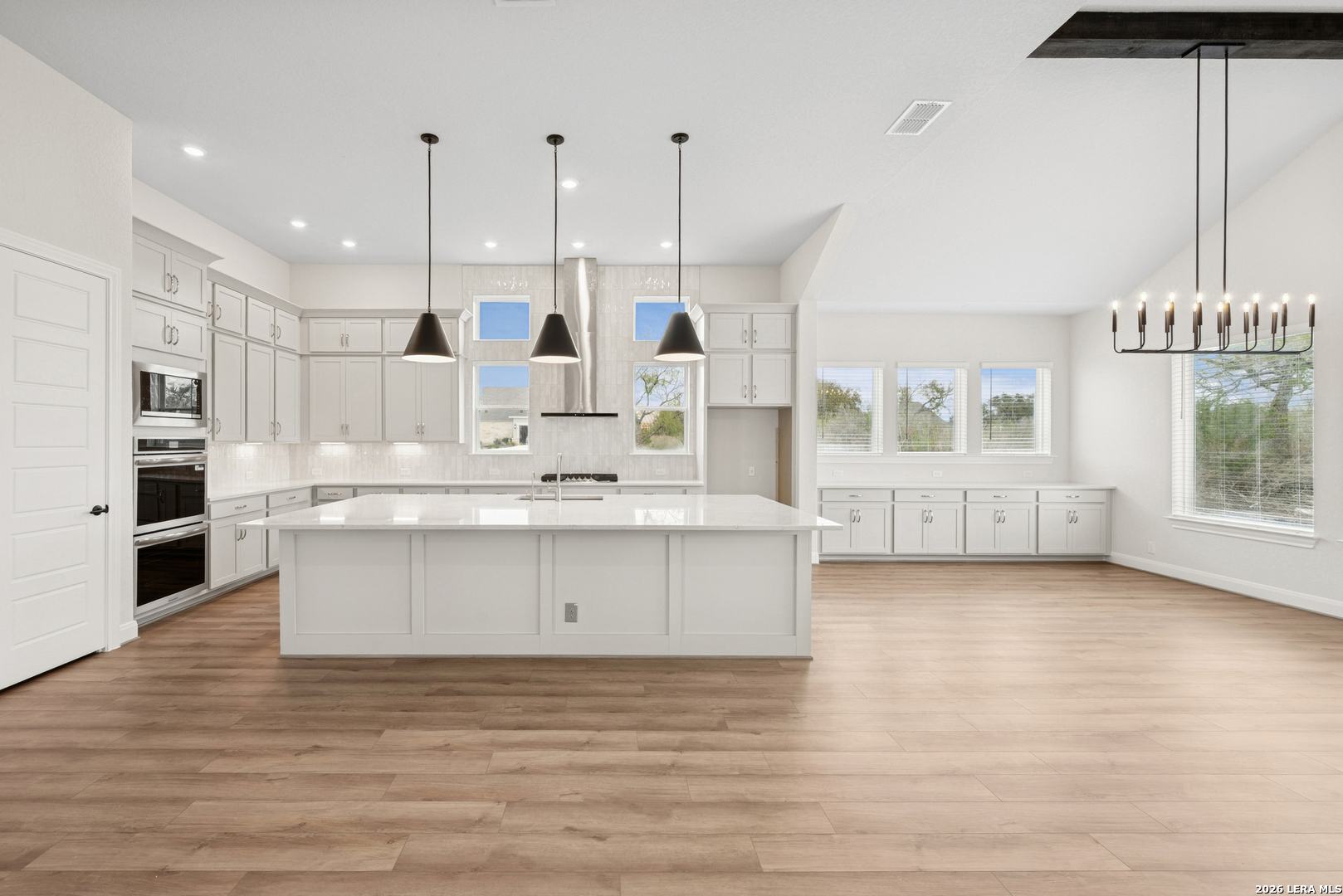 761 Falcon Cove Castroville, TX 78009 - Photo 10 of 11 a large white kitchen with kitchen island white cabinets and stainless steel appliances
