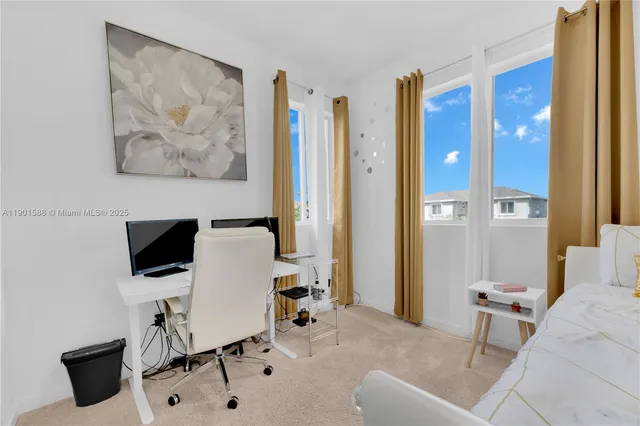 a view of a workspace with furniture and a window