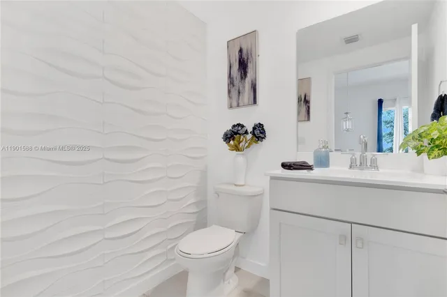 a bathroom with a sink mirror vanity and toilet