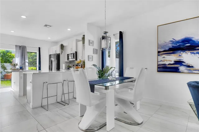 a kitchen with stainless steel appliances kitchen island granite countertop a refrigerator and cabinets