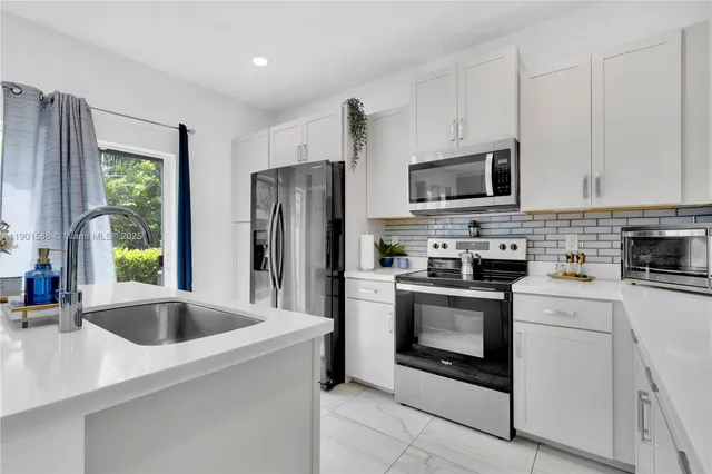 a kitchen with appliances a sink and a counter top space