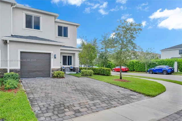 a front view of a house with a yard and trees