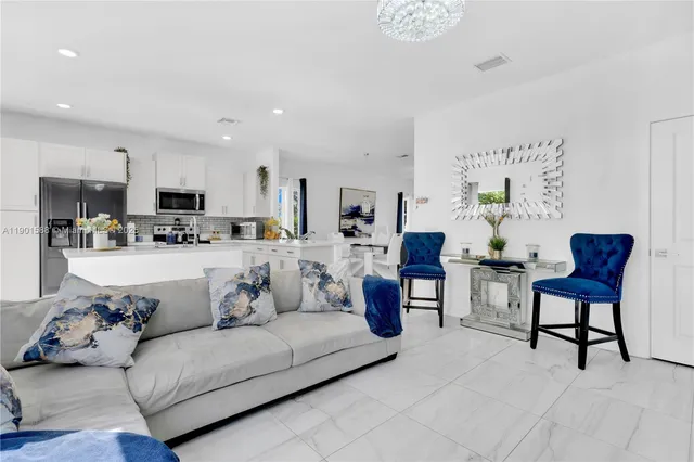 a living room with furniture and a dining table with kitchen view