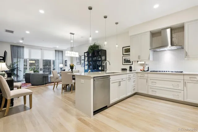 a kitchen with stainless steel appliances a sink a stove a refrigerator and cabinets