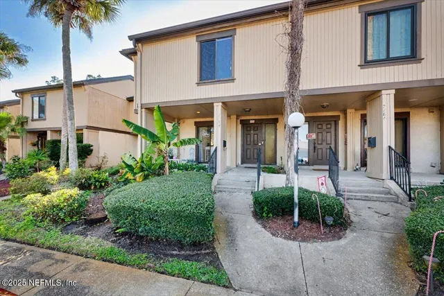 a front view of a house with garden and plants