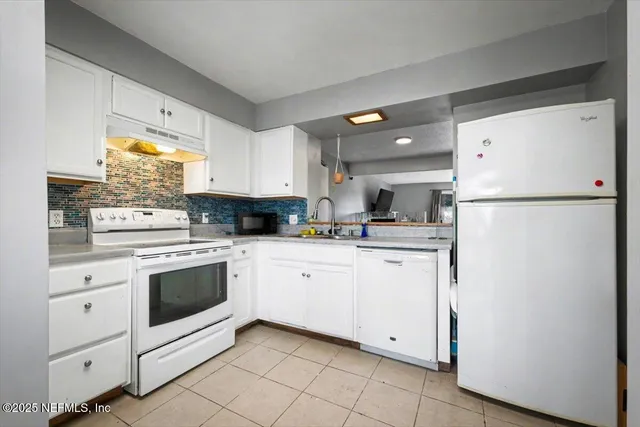 a kitchen with white cabinets and white appliances