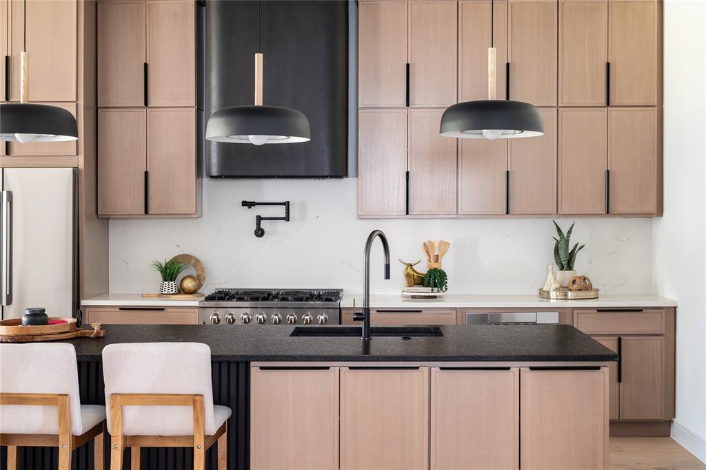 a kitchen with stainless steel appliances granite countertop a sink and a stove
