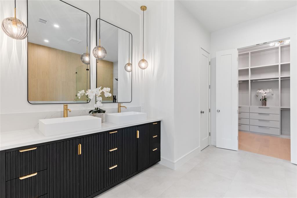4322 Sexton Lane Dallas, TX 75229 - Photo 9 of 34 a bathroom with a double vanity sink a mirror and a bathtub
