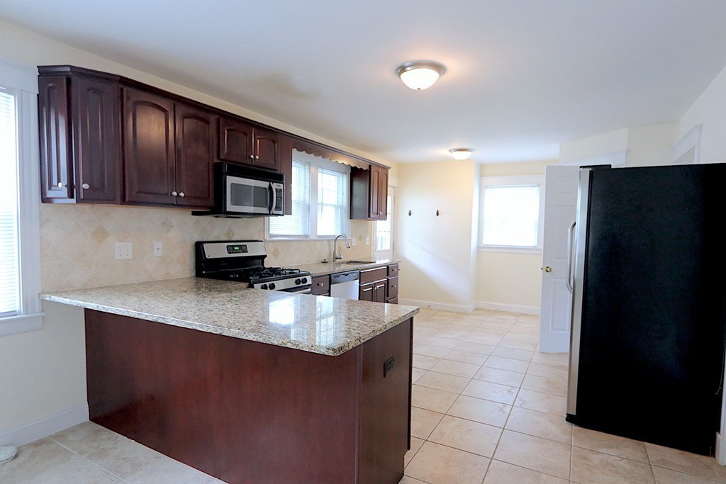 84 Withington Road Newton, MA 02460 - Photo 1 of 1 a kitchen with stainless steel appliances granite countertop a refrigerator a stove a sink a microwave and a refrigerator