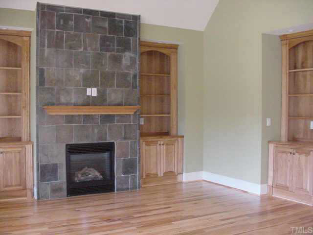 The Family Room has 3 hickory wood built in shelf and storage areas with a tiled fireplace over mantel and surround. Other