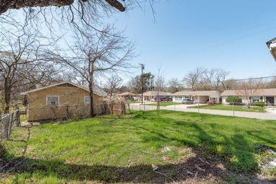930 Freeman Street Sherman, TX 75092 - Photo 18 of 18 Expansive grassy lot featuring mature trees and a chain-link fence