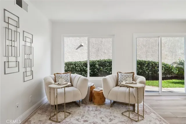 a view of a white house with a big yard and potted plants and big trees