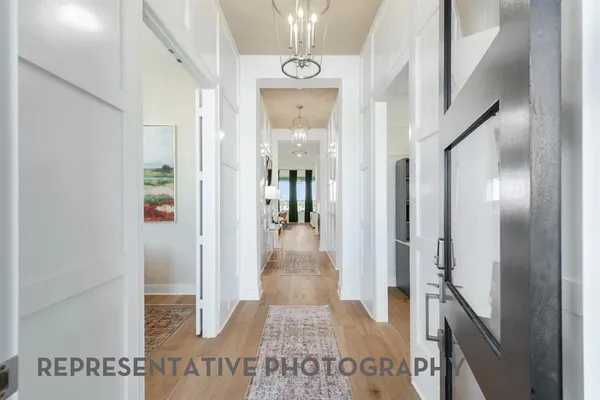 a view of a hallway with wooden floor and staircase