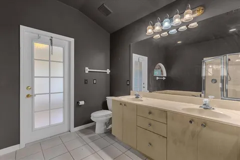 a spacious bathroom with a granite countertop sink a toilet and a mirror