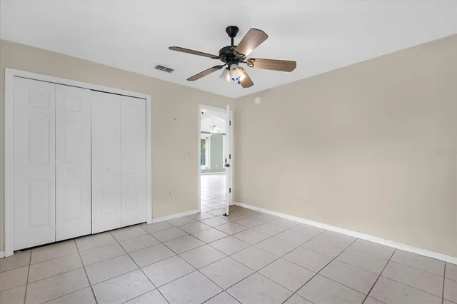 a view of an empty room and chandelier fan