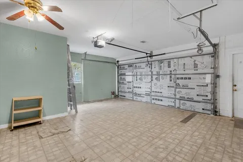 a view of an empty room with cabinet and a ceiling fan