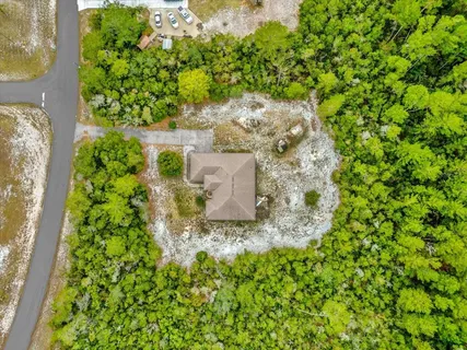 an aerial view of residential houses with outdoor space and trees