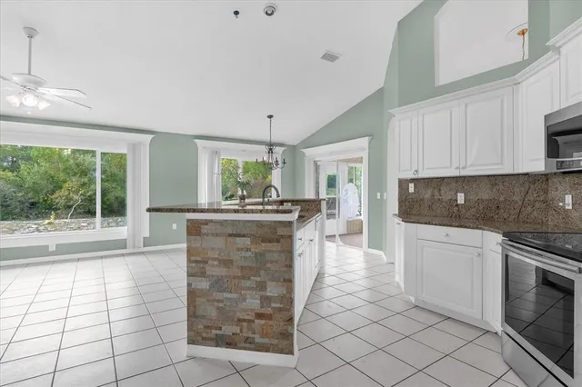 a kitchen with granite countertop a stove a sink and a microwave