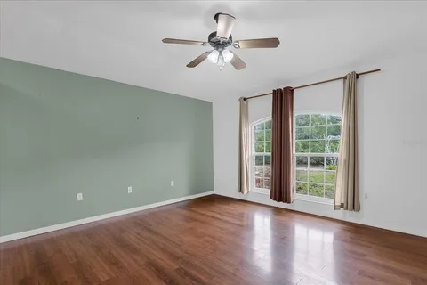 a view of room with window ceiling fan and hardwood floor