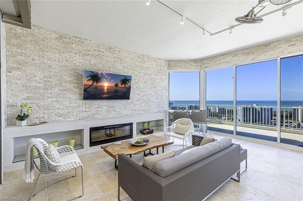 295 Grande Way, Unit PH2 Naples, FL 34110 - Photo 21 of 45 a living room with furniture a flat screen tv and a fireplace