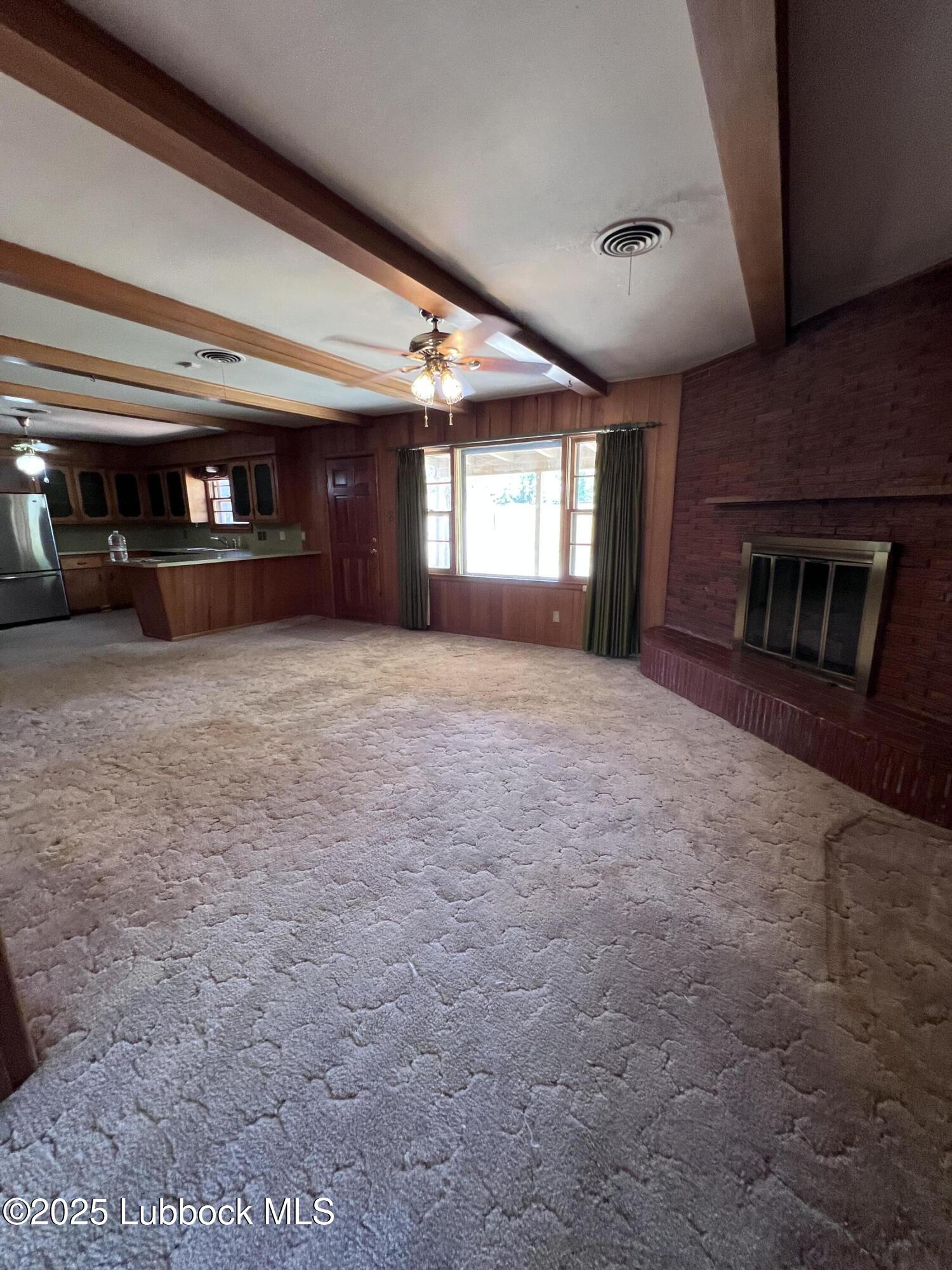 2304 54th Street Lubbock, TX 79412 - Photo 2 of 18 a view of an empty room with a fireplace and a window