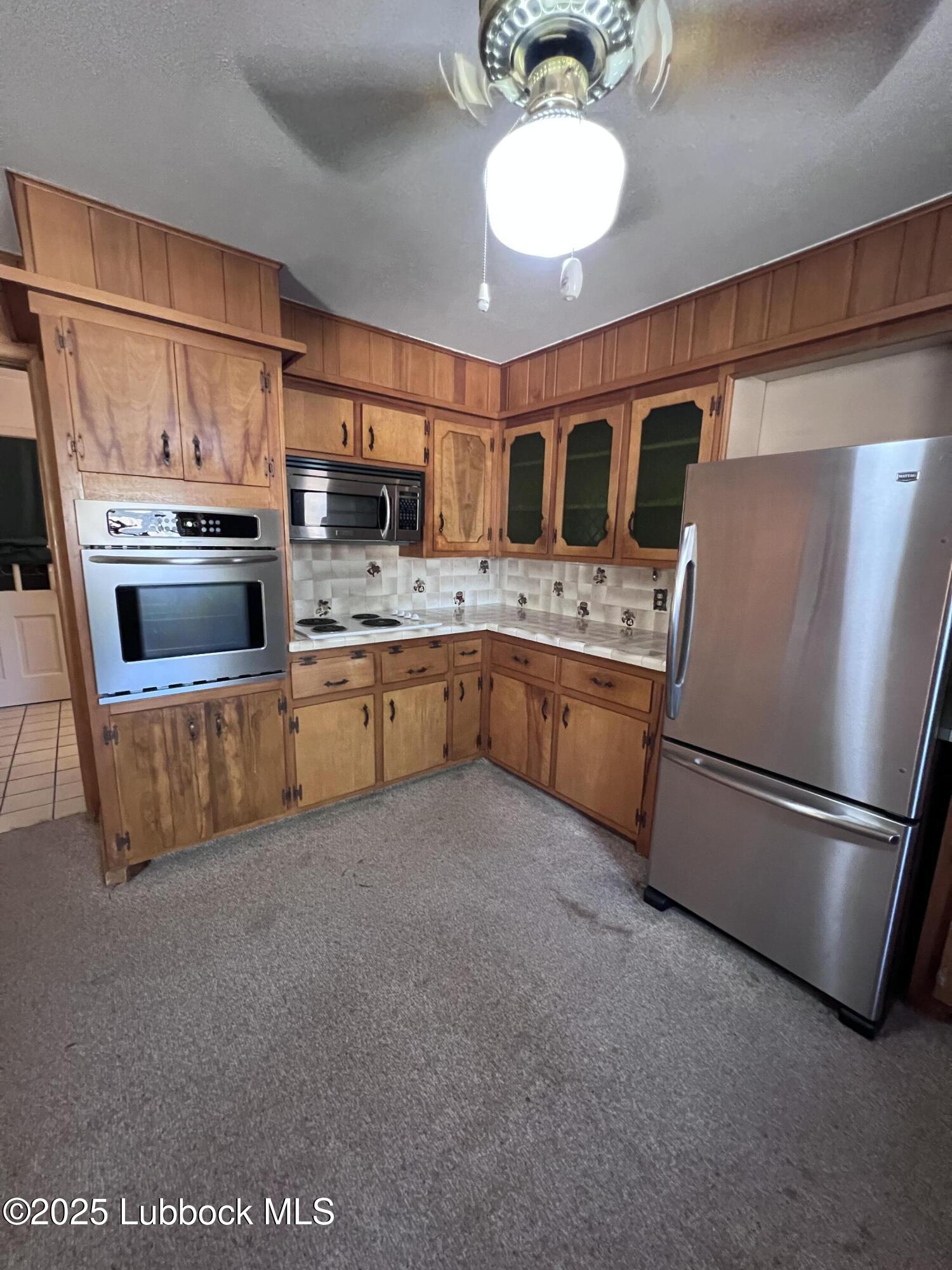 2304 54th Street Lubbock, TX 79412 - Photo 4 of 18 a kitchen with stainless steel appliances granite countertop a refrigerator a stove a sink and a microwave