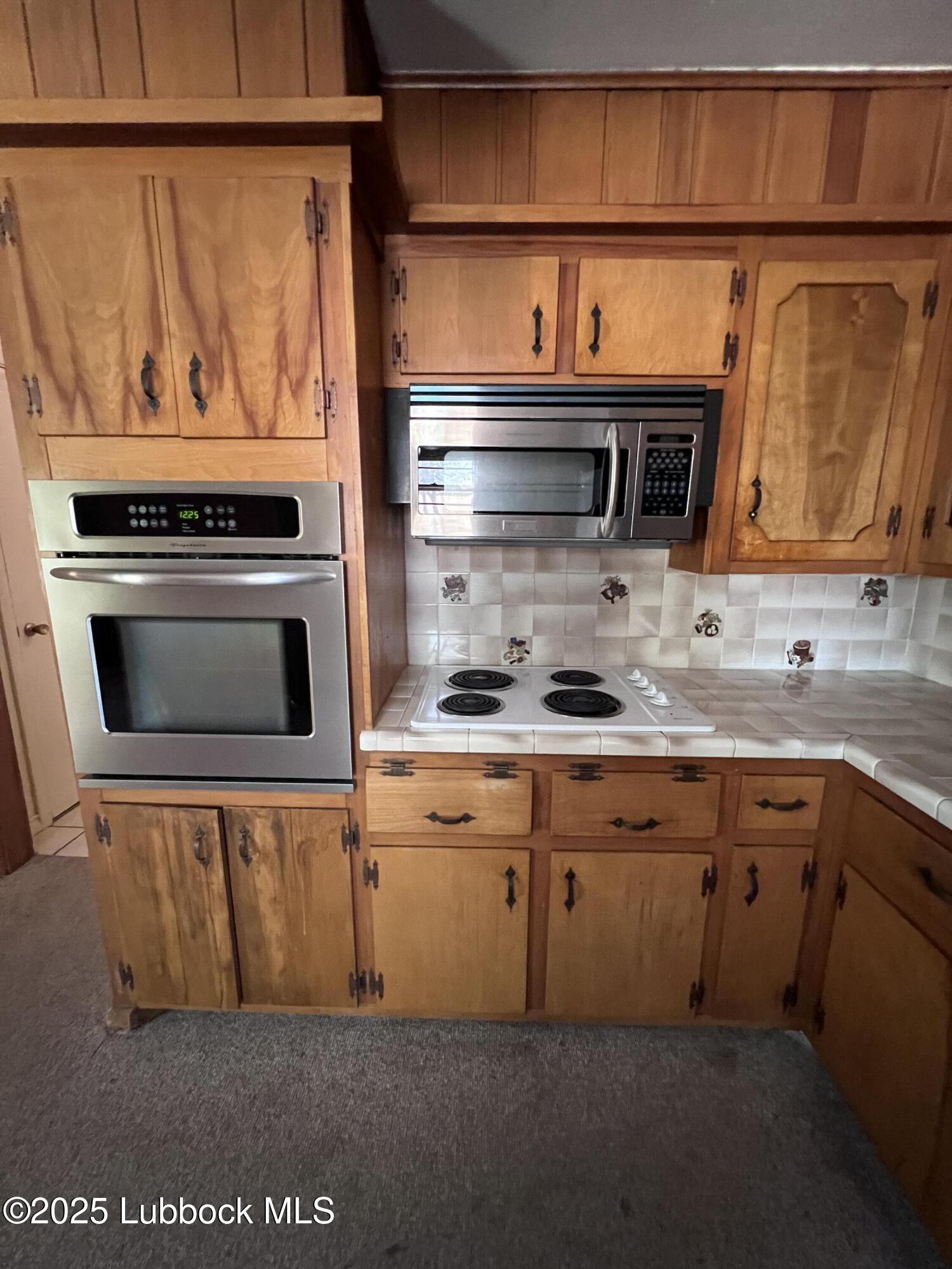 2304 54th Street Lubbock, TX 79412 - Photo 5 of 18 a kitchen with granite countertop a sink and cabinets