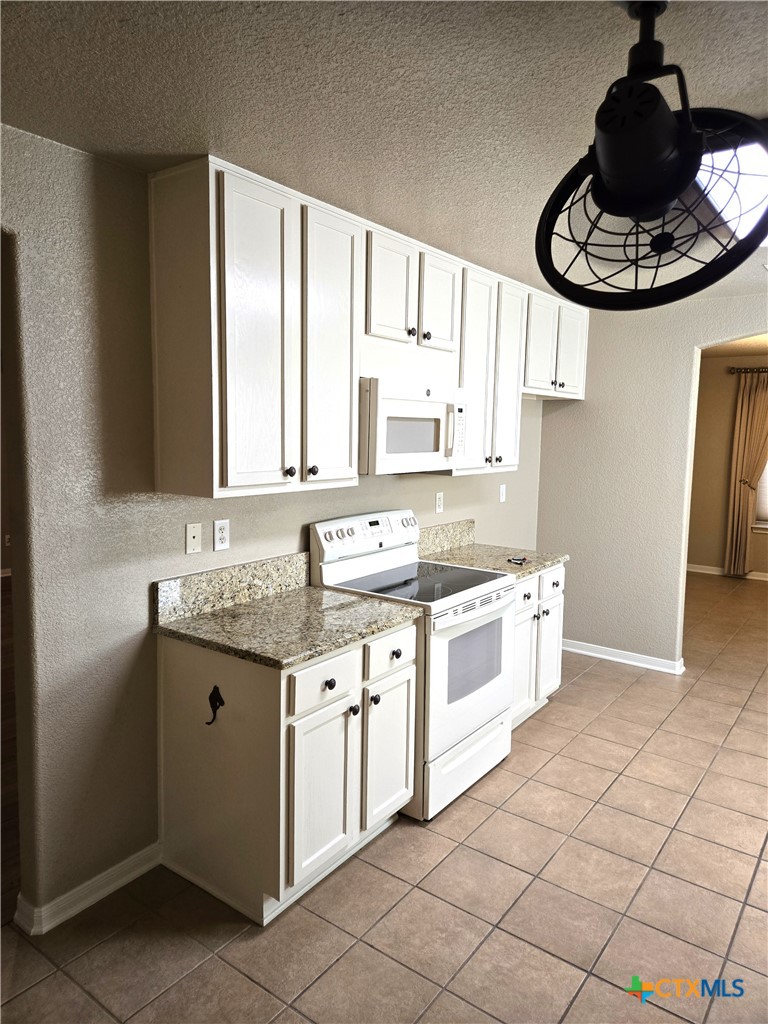 6308 Roxbury Avenue Temple, TX 76502 - Photo 11 of 26 a kitchen with stainless steel appliances granite countertop a stove a sink and a refrigerator