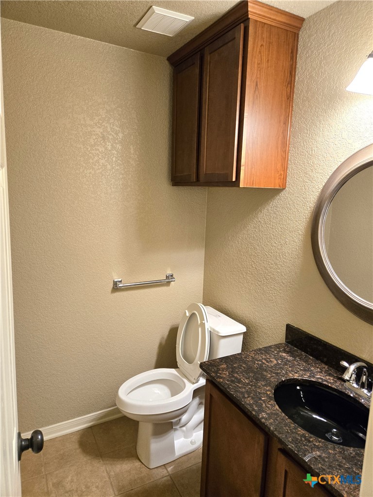 6308 Roxbury Avenue Temple, TX 76502 - Photo 24 of 26 a bathroom with a granite countertop toilet and a sink