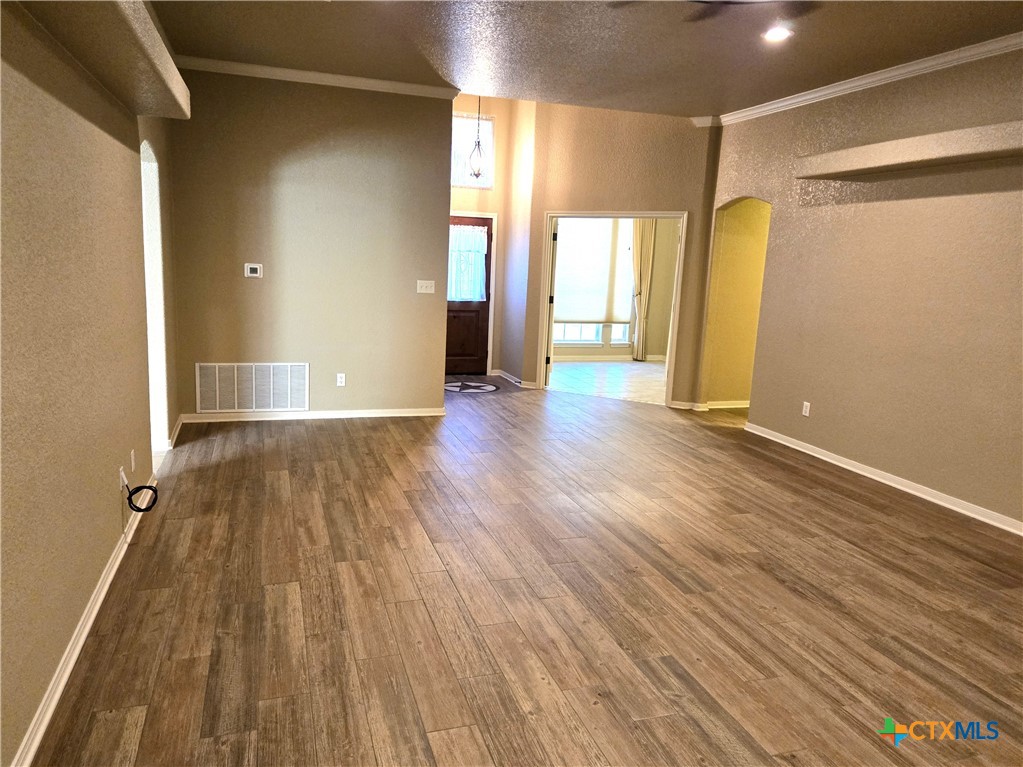 6308 Roxbury Avenue Temple, TX 76502 - Photo 7 of 26 a view of an empty room with wooden floor and a window
