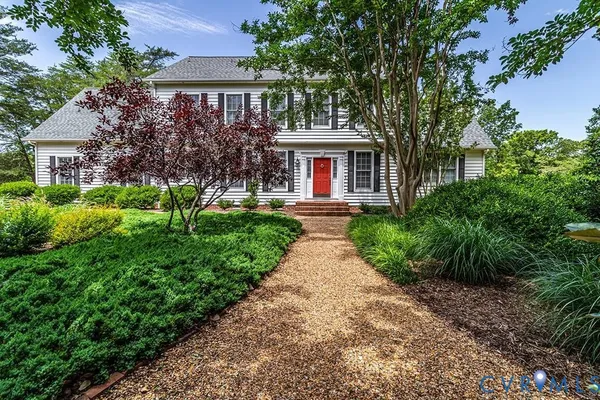 a front view of a house with a yard and potted plants