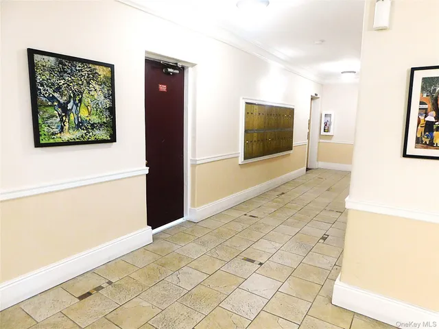 a view of a hallway with wooden floor and a flat screen tv