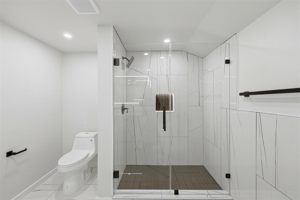 502 Madison Street Cleburne, TX 76033 - Photo 16 of 30 a bathroom with a shower a toilet and a sink