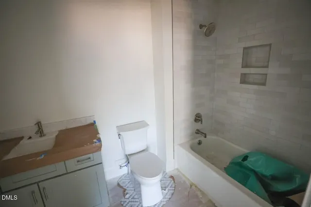 a bathroom with a granite countertop toilet and sink