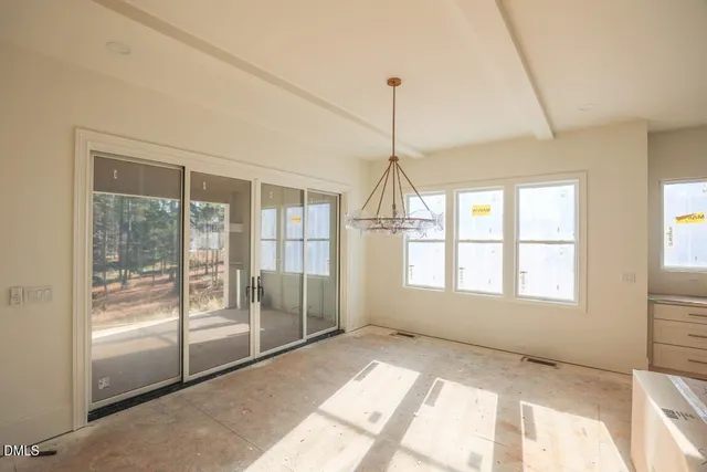 a view of an empty room with cabinet and a window