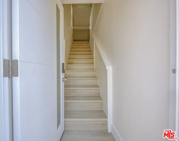 an empty room with wooden floor and cabinet
