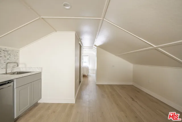 a view of a room with wooden floor and electronic appliances