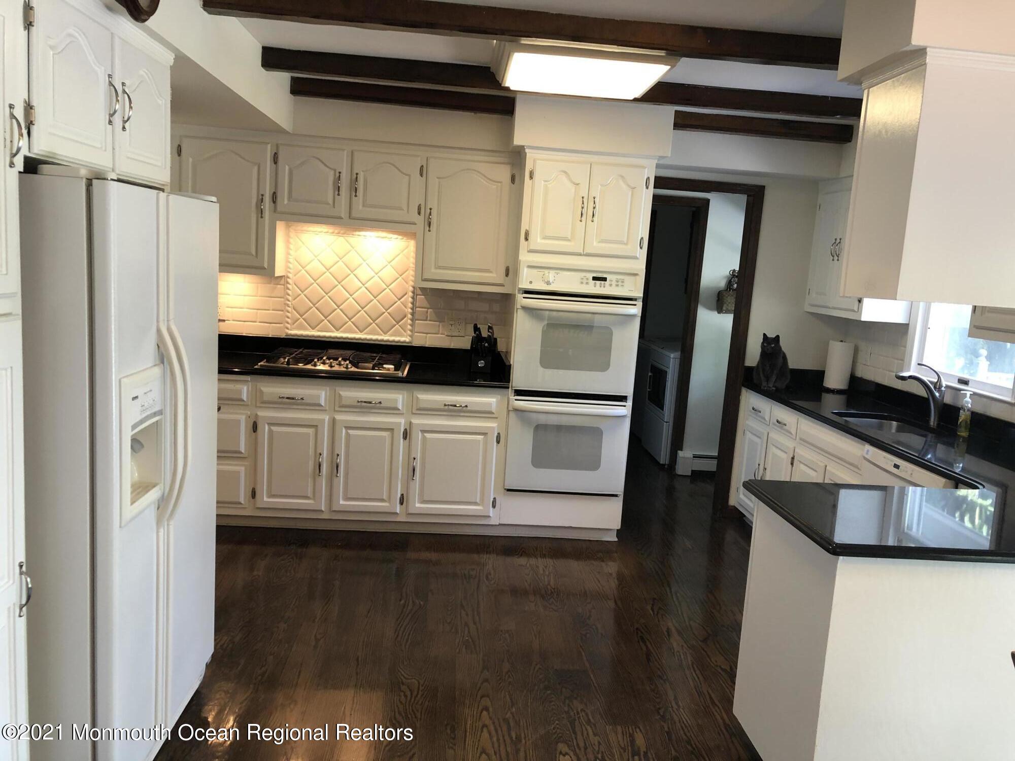 2 Hunt Road Freehold, NJ 07728 - Photo 16 of 35 a kitchen with stainless steel appliances a refrigerator a sink and white cabinets