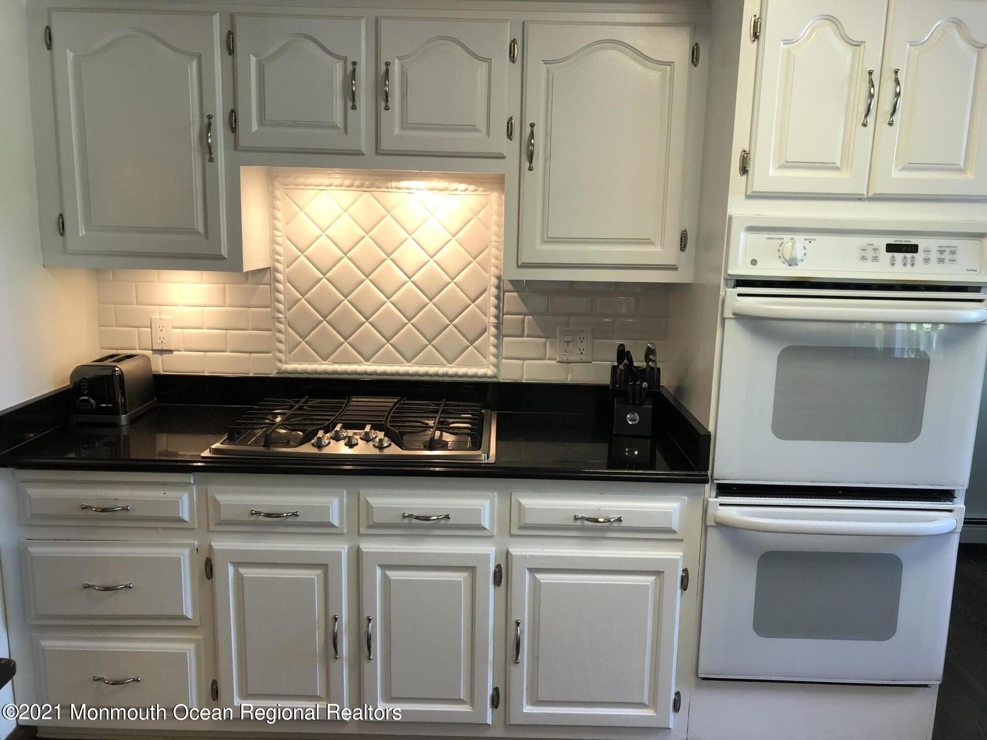 2 Hunt Road Freehold, NJ 07728 - Photo 17 of 35 a kitchen with white cabinets and appliances