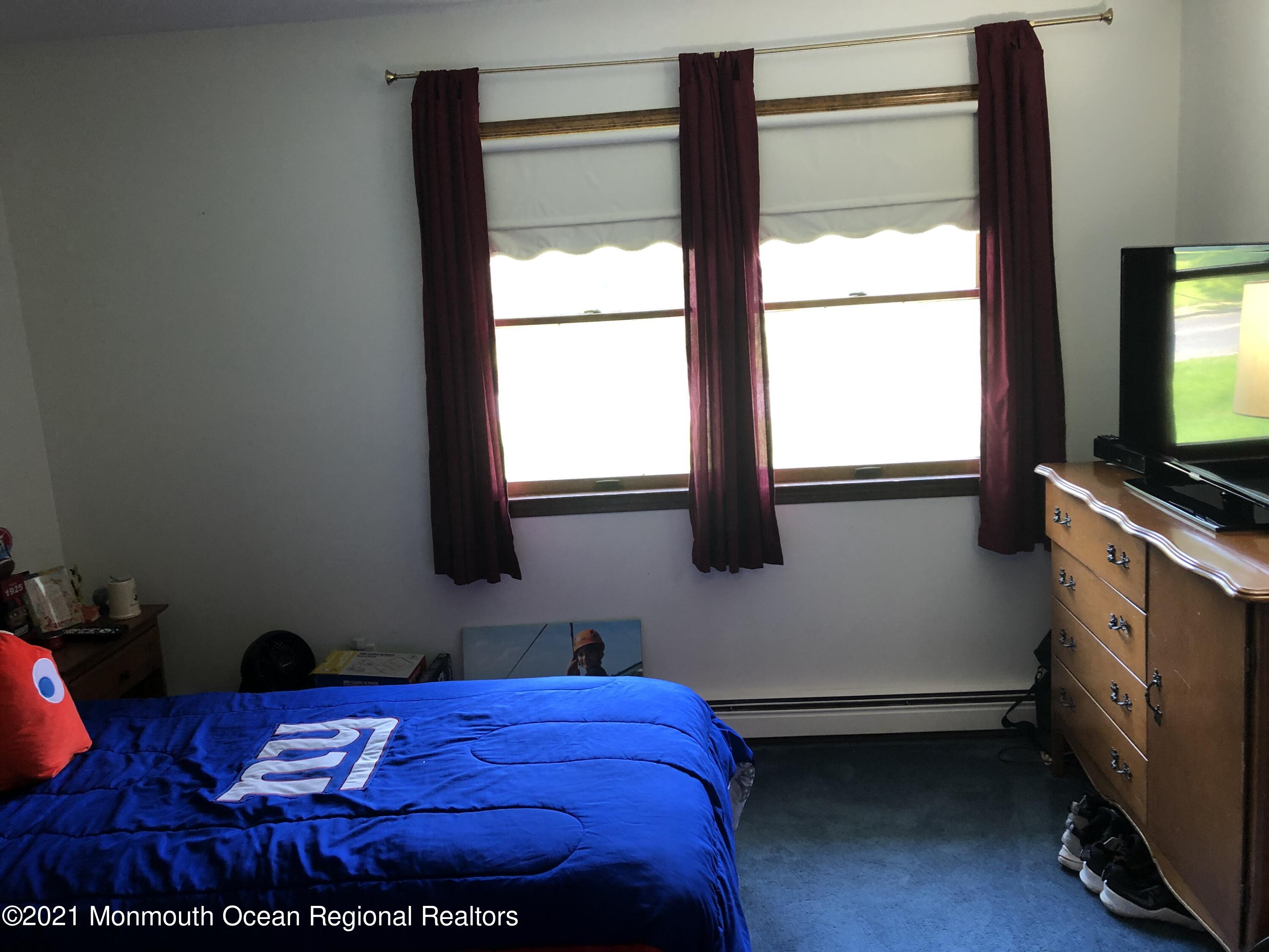 2 Hunt Road Freehold, NJ 07728 - Photo 22 of 35 a bedroom with a bed and a flat tv screen on a dresser