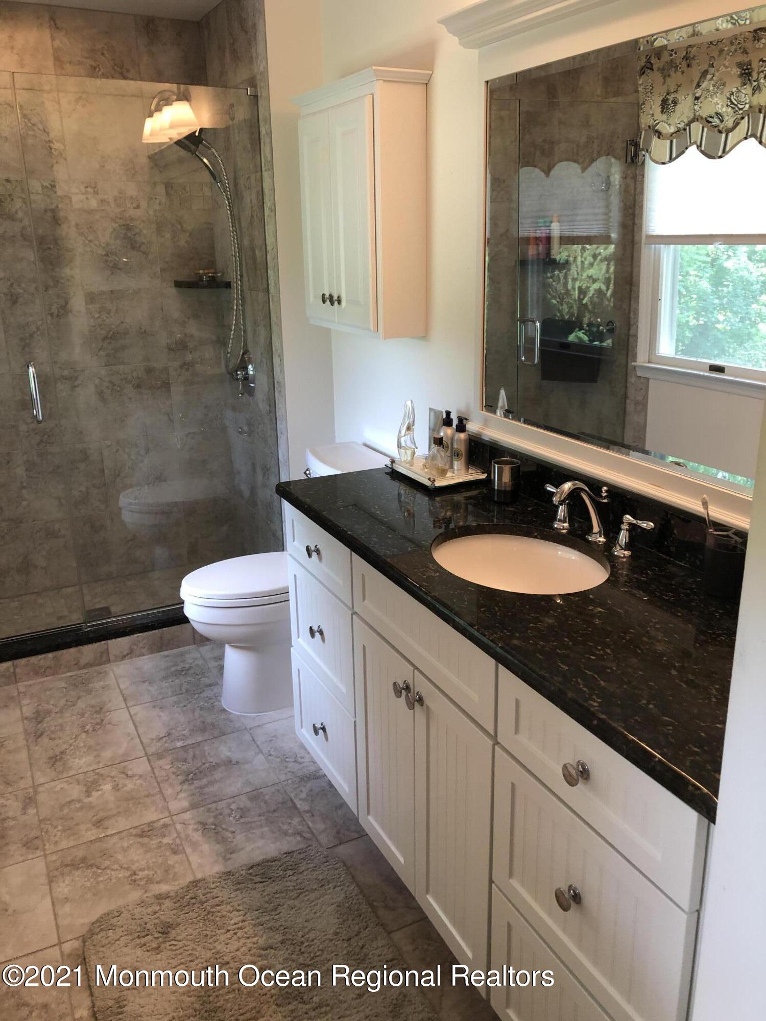 2 Hunt Road Freehold, NJ 07728 - Photo 30 of 35 a bathroom with a sink a toilet a mirror and shower