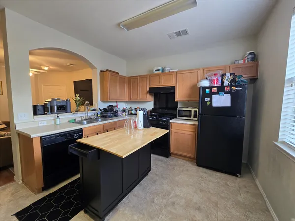 a kitchen with stainless steel appliances granite countertop a refrigerator a sink dishwasher a stove and a refrigerator