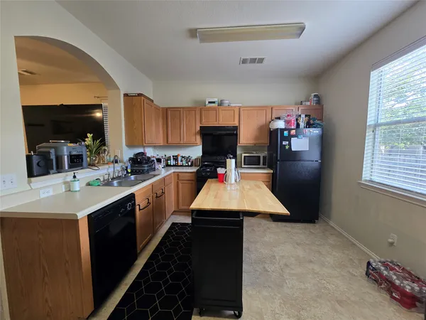 a kitchen with kitchen island granite countertop a sink appliances and cabinets