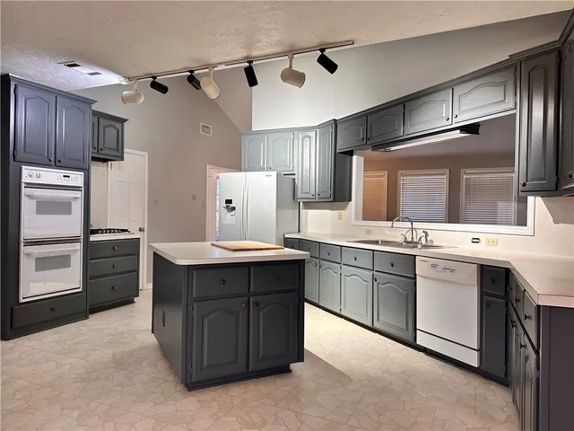 a kitchen with granite countertop a sink appliances and cabinets