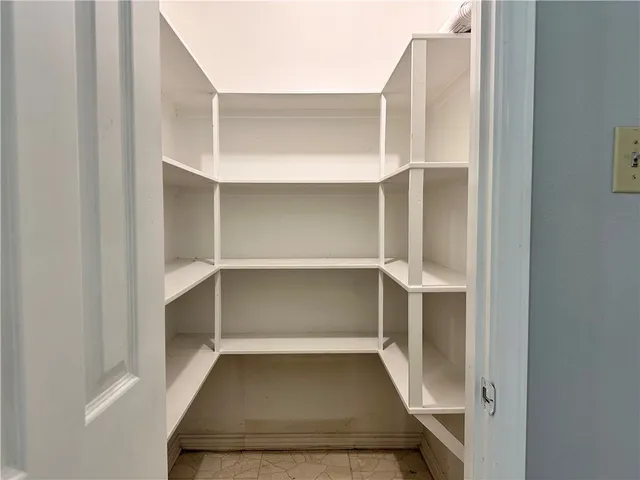 a view of walk in closet with empty racks