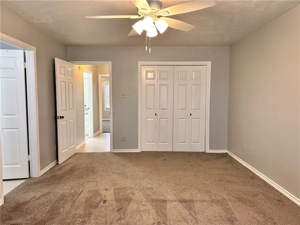 an empty room with fan and windows